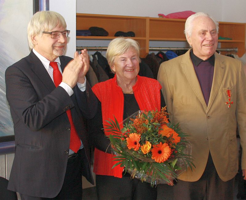 Oberbürgermeister Rolf-Georg Köhler (links) übergab das Bundesverdienstkreuz an Günter Berg, Ehefrau Eva erhielt einen Blumenstrauß